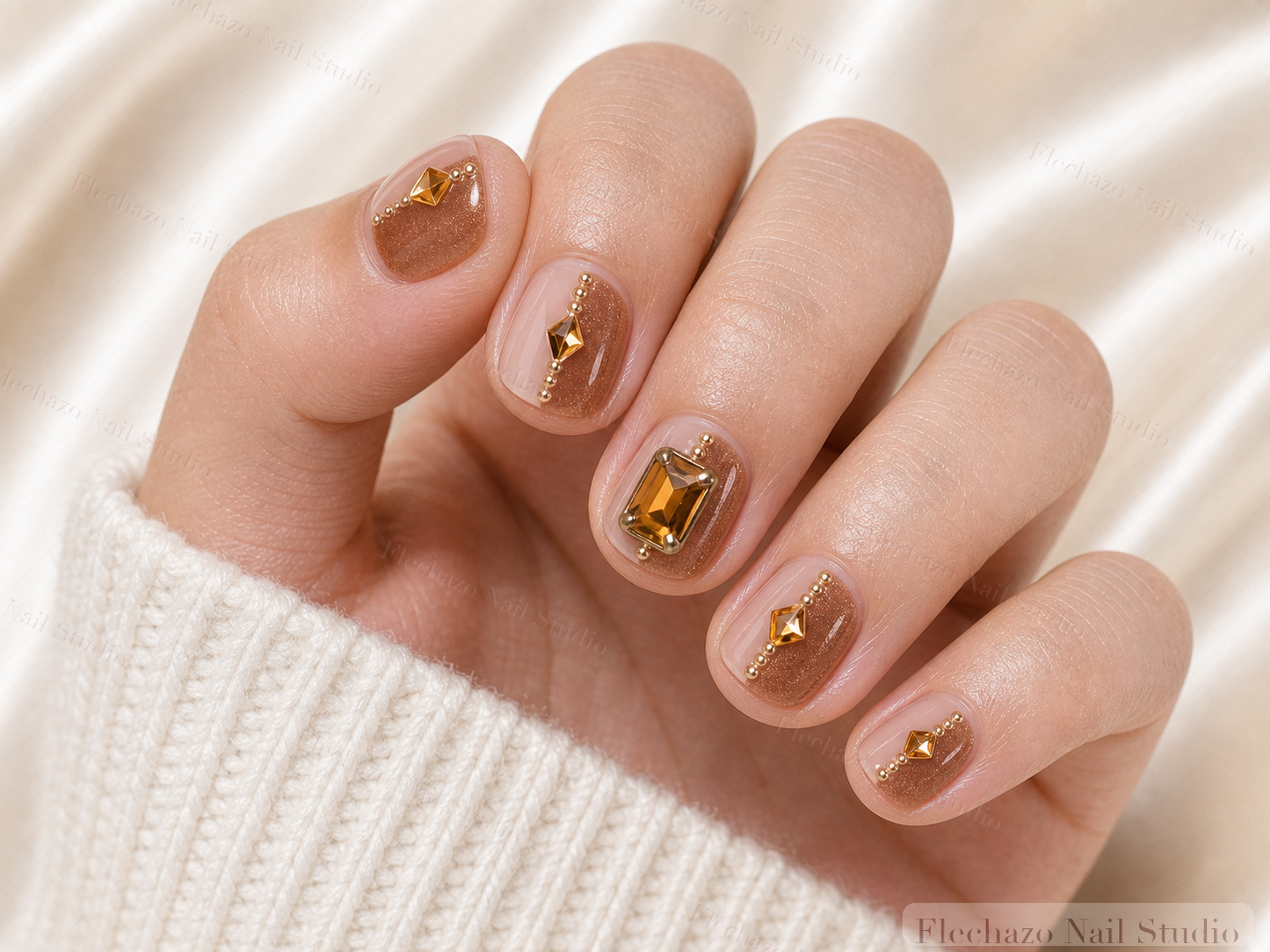 Caramel Gold Bow Jewel Press-On Nails worn on a model hand