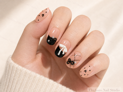 Black Nude Bow Pearl Press-On Nails worn on a model hand