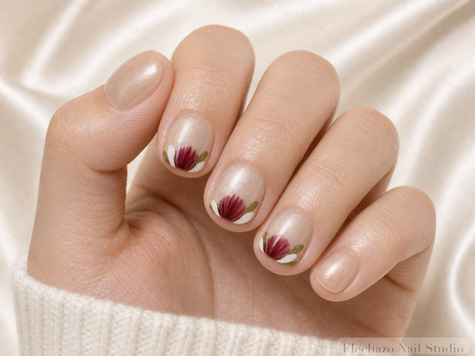 Champagne Shimmer Hand Painted Red Press-On Nails worn on a model hand